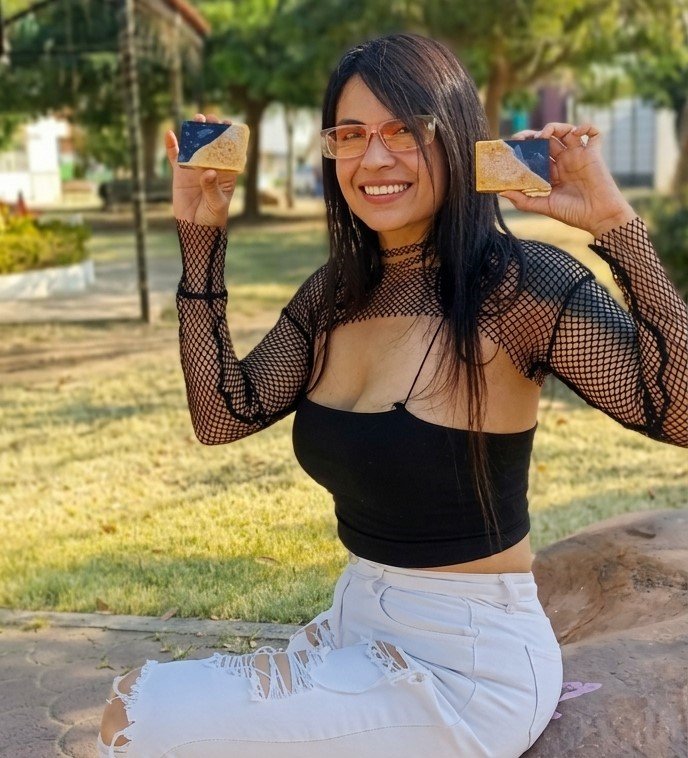 Iris sosteniendo dos barras de jabón artesanal en un parque